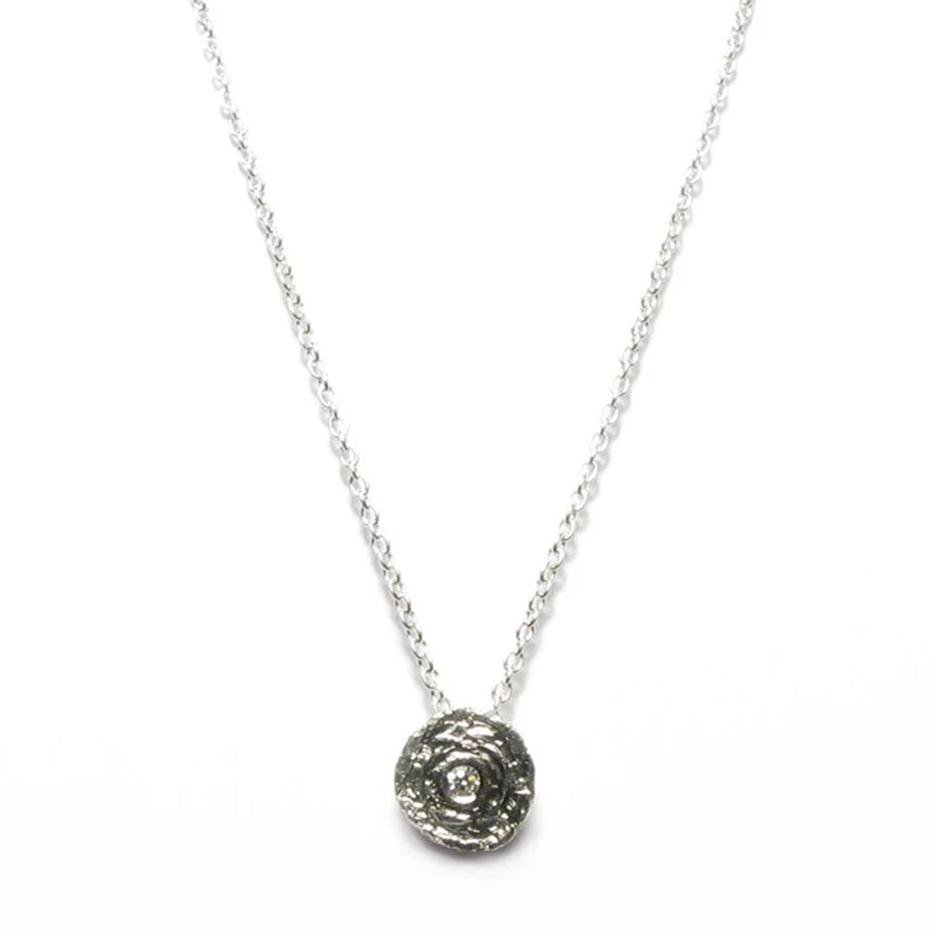 round etched silver pendant with a diamond in the centre on a fine trace chain by contemporary jeweller diana porter
