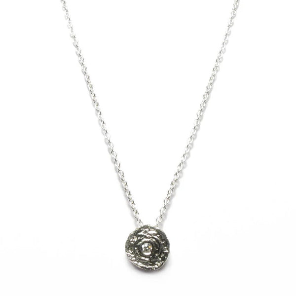 round etched silver pendant with a diamond in the centre on a fine trace chain by contemporary jeweller diana porter
