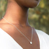 model wearing round etched silver pendant with a diamond in the centre on a fine trace chain by contemporary jeweller Diana Porter
