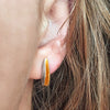 Close-up of an ear wearing front split silver shell stud with a rich 22ct gold plated interior. These simple sterling silver earrings have a natural organic form