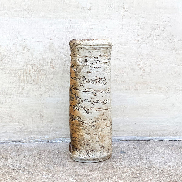 A rough textured flat vase in neutral colours, and a blue glazed interior