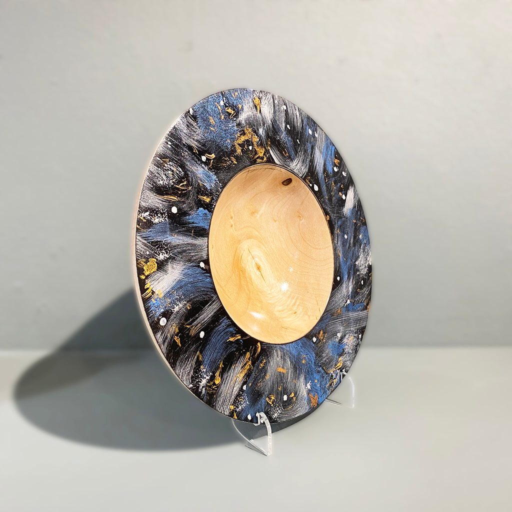 Side View of turned sycamore bowl with blue and gold abstract design  hand painted using acrylic to resemble a celestial scene, then coated with a lacquer finish and polished by Bernie Yates