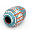 Side view of hand carved Tangerine and Blue Nerikomi vase by contemporary ceramicist Corinne Price with a bold design, working with the clay to produce an abstract design.