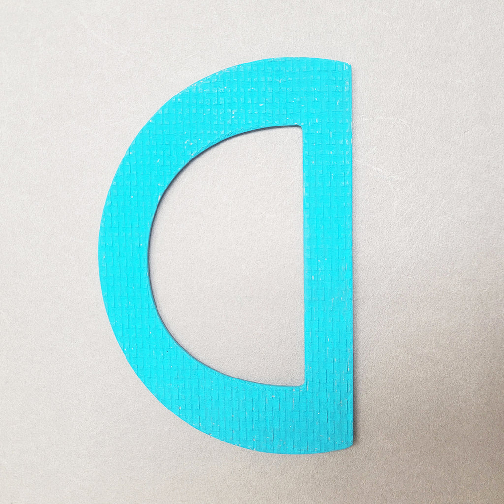 Teal D-shaped bangle inspired by the Bauhaus design movement. Made from linoleum and hand painted  by Studio Ditto in Liverpool
