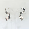pair of twisted sterling silver drop earrings by Irish Silversmith Kevin O’Dwyer shown on a stand in Bluecoat Display Centre