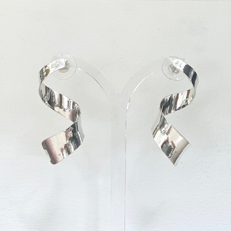 pair of twisted sterling silver drop earrings by Irish Silversmith Kevin O’Dwyer shown on a stand in Bluecoat Display Centre