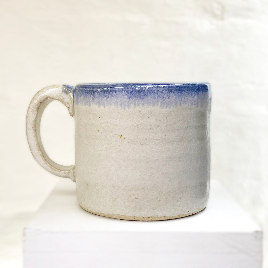 rear of beautiful hand thrown ceramic mug featuring a winter scene with people sledging in the snow by Julia Smith