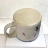 base of beautiful hand thrown ceramic mug featuring a winter scene with people sledging in the snow by Julia Smith