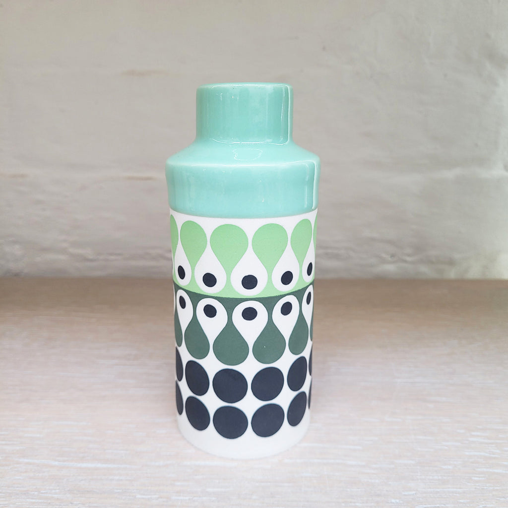 Cylinder vase by Maree and Paul Allitt this piece is predominently white background with shades of green and black in the pattern