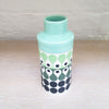 top view of Cylinder vase by Maree and Paul Allitt this piece is predominently white background with shades of green and black in the pattern