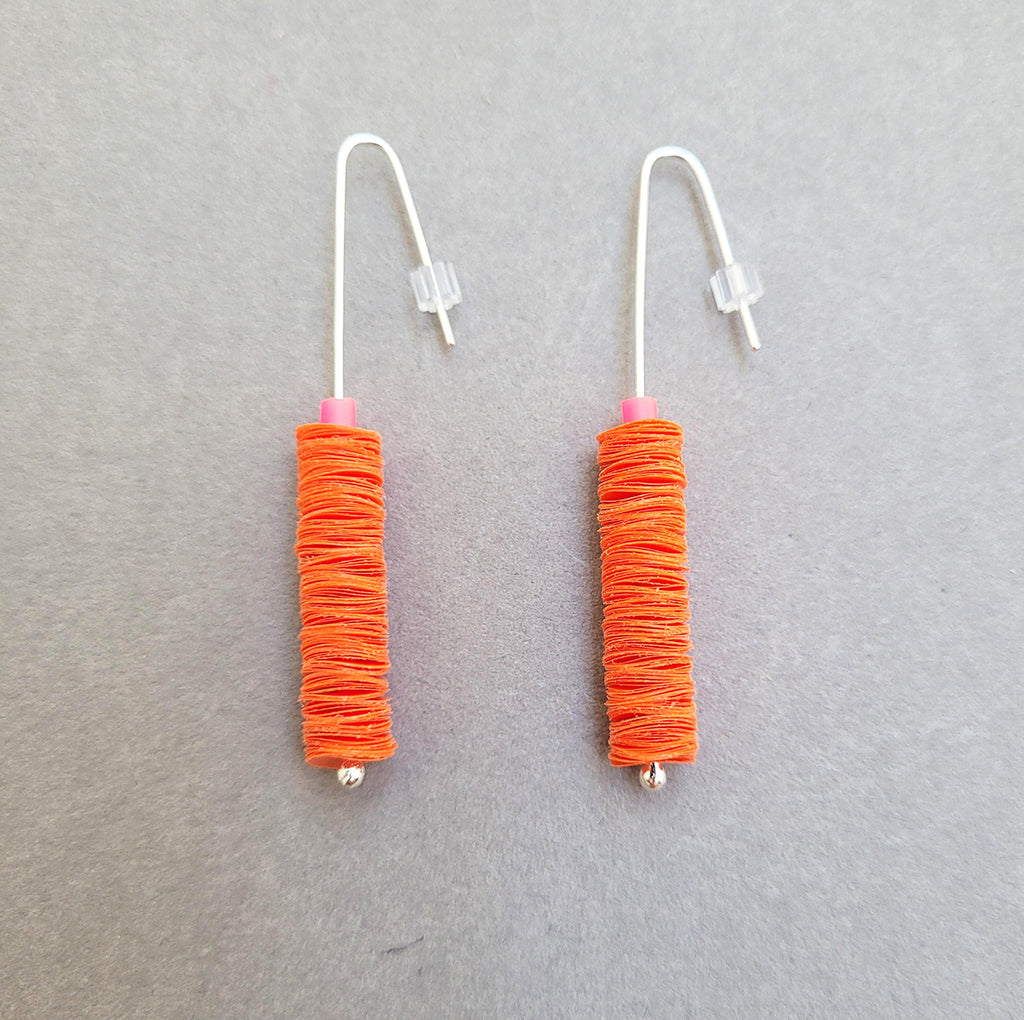 These orange drop earrings are made from recycled polythene bags with silver earring posts by contemporary jewellery designer Rachel Darbourne
