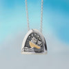 movie of silver kinetic pendant by Alan Ardiff Contemporary Irish Jeweller.  based on the famous poem the owl and the pussycat. The pendant features a silver owl and pussycat going to sea in a gold boat amongst the rocking waves.