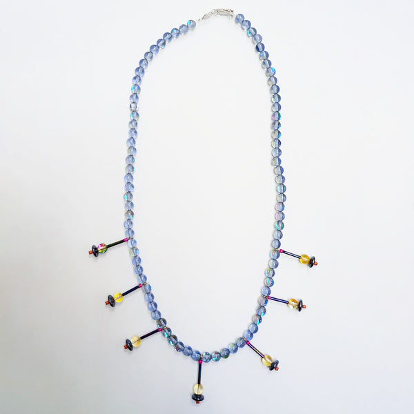 This unique and stunning dyed quartz bead necklace has bugle style beads, and single quartz beads with a sterling silver clasp. It has a fresh colourway which is predominently pale blue enhanced by shots of yellow, pink and orange