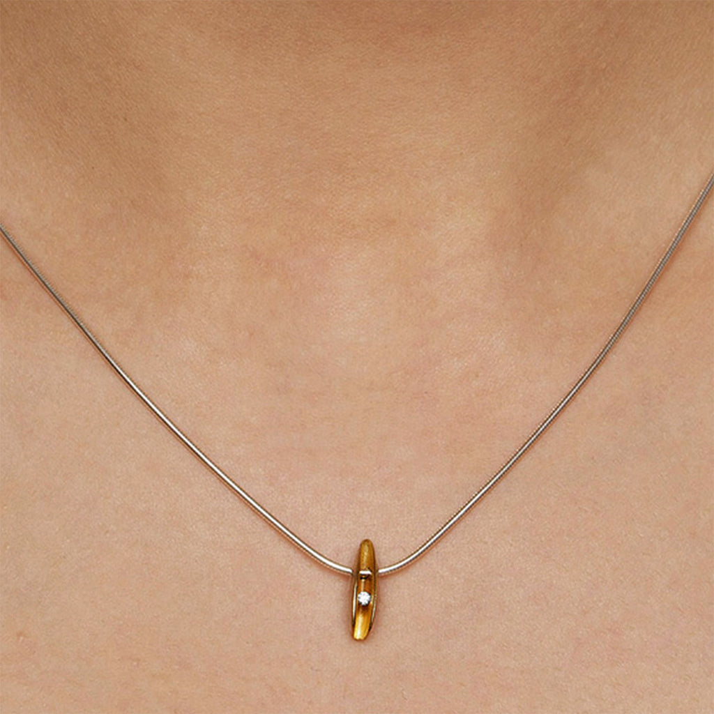 silver shell pendant with 2pt diamond and a rich gold plated interior by Paul Finch contemporary jeweller shown worn