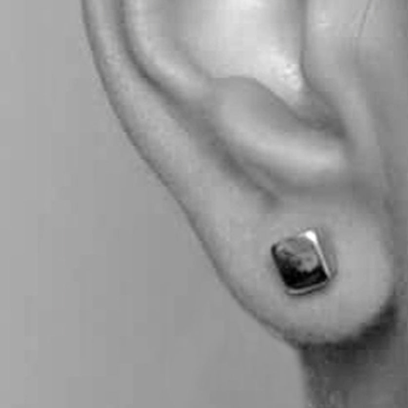 Close-up of an ear wearing a  Square silver stud in 925 sterling silver by Paul Finch