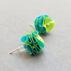 Side view of studs in yellow and mid blue made from recycled polythene bags with silver earring posts by contemporary jewellery designer Rachel Darbourne