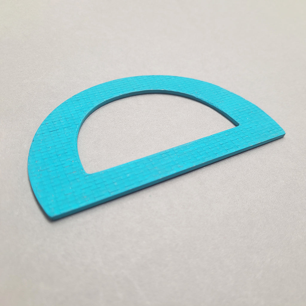 Side angle view of Teal D-shaped bangle inspired by the Bauhaus design movement. Made from linoleum and hand painted by Studio Ditto