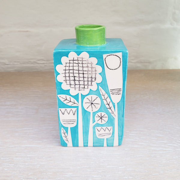 This turquoise bottle vase is both functional and decorative on it's own. It is a striking turquoise colour - with a pop of green - and features Ken's distinctively retro patterns which are reminiscent of Scandinavian folk art